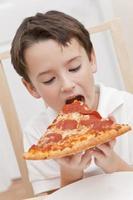 Young Boy Child Eating Slice of Pizza photo