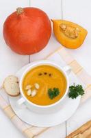 Pumpkin soup with baguette in cup photo