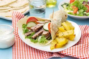 Greek gyros with pork, vegetables and homemade pita bread photo