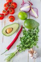 Guacamole ingredients - avocado, tomatoes, onion, garlic, lime