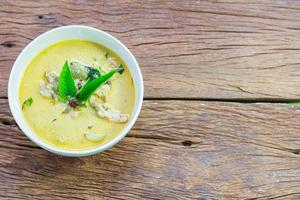 Thai chicken green curry with old wooden background photo