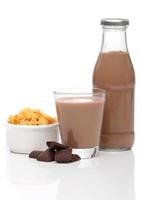 Chocolate milk and cornflakes over white background photo