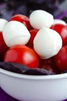 Mozzarella and cherry tomatoes in a porcelain  bowl photo
