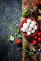 Cherry tomatoes, basil leaves, mozzarella cheese and olive oil f photo