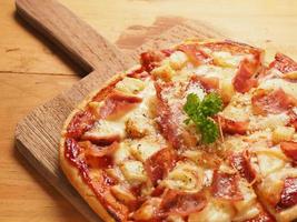 pizza hawaiana en placa de madera