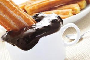 porras, thick churros typical of Spain, dipped in hot chocolate photo