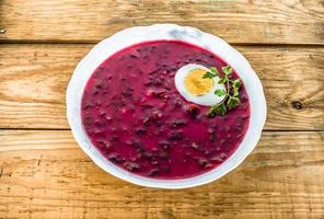Borscht with beets with hard boiled egg with sour cream. photo