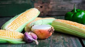 raw corn on the cob .on a green wooden background, .vegetables
