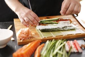 maestro de sushi prepara futomaki foto