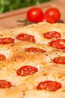Flat bread with cherry tomatoes (italian focaccia) close-up photo