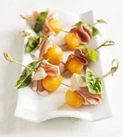 Appetizer with melon and prosciutto on skewers