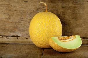 Yellow cantaloupe melon on the wooden background photo