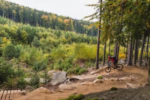 Mountain biker riding cycling in autumn forest photo