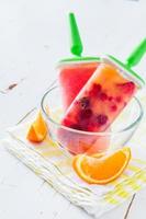 hielo de fruta aparece en un tazón de vidrio, rodajas de naranja foto