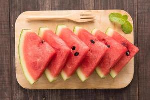 Fresh watermelon pieces placed on wooden background photo