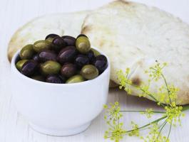 Bowl of olives and pita with fennel's flower photo