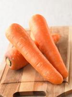 close up fresh and sweet carrot on wood plate photo