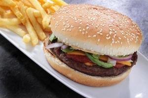 burger in seeded bun with fries and salad photo