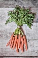 Fresh carrots on grungy wooden background photo