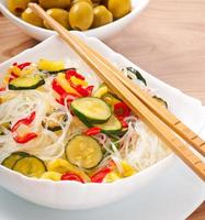 fideos de arroz y verduras en plato blanco