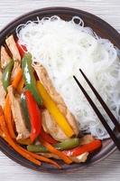 Rice noodles with chicken macro, vertical top view photo