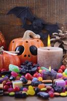 Halloween Candy with pumpkins on dark wood background. photo