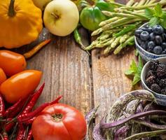 coloridas verduras frescas de todos los colores en el fondo de madera foto