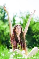 Woman with arms raised in meadow photo