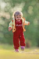 Active little girl running on a meadow