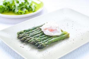 Fresh cut green cooked asparagus with fried eggs