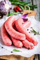raw homemade sausages on cutting board photo