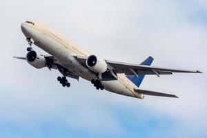 Avión de pasajeros contra el cielo azul nublado foto