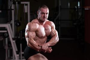 hombre musculoso flexionando los músculos foto