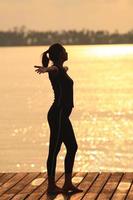 Yoga woman in serene sunset .