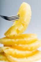 Sliced pineapple. Canned fruits on fork. Macro