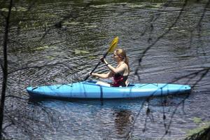 Young woman in kayak, water in Sunapee, New Hampshire, horizonta