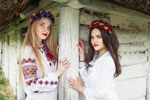 Two young beautiful  girls with long hair in Ukrainian blouses