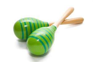 A pair of green maracas with blue stripes on white back