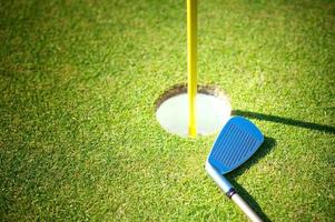 Golf cup with club on green background