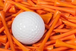 White golf ball lying between wooden tees