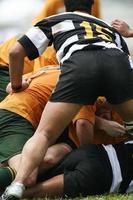 Rugby teams in a pile on as they tackle photo