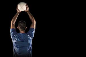 Composite image of rugby player holding ball