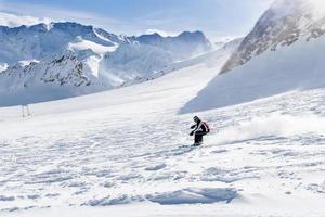 joven esquiador cuesta abajo en la pista de esquí