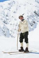 joven esquiador vintage posando en las montañas foto