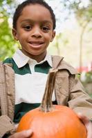 Boy holding a pumpkin photo