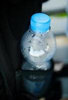 botella de agua de plástico en el bolsillo de la mochila foto