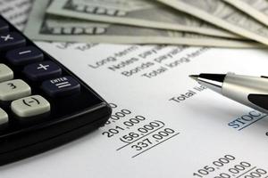 US currency, calculator and financial documents closeup