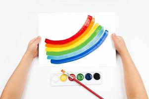Child draws the rainbow watercolors