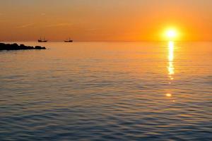 puesta de sol y barco foto