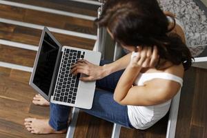 mujer usando laptop en escalera foto
